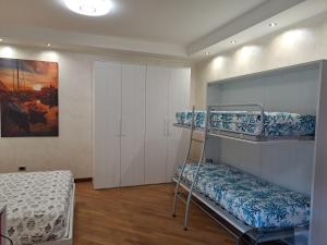 热那亚La casa sul molo - Acquario的客房设有两张双层床和一张床。