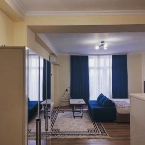 阿克套Rusel Hotel的客厅配有蓝色的沙发和床。