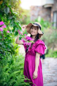宁平Khu du lịch Hoa và Đá的穿着粉红色连衣裙和花帽的年轻女孩