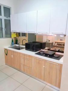 振林山Condo @ Bukit Indah/ Legoland/ Eco Botanic 6 pax的厨房配有水槽和微波炉
