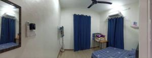 浮罗山背Ainaz Homestay Balik Pulau的一间医院房间,配有蓝色窗帘和镜子