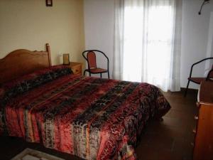 RibatajadillaHotel Rural El Cuco的一间卧室配有一张床、两把椅子和一个窗户