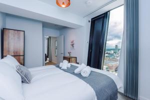 曼彻斯特Hilltop Serviced Apartments - Deansgate的卧室设有一张大白色的床和大窗户