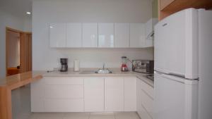 乌鲁阿潘Shanarani Apartament的白色的厨房配有水槽和冰箱
