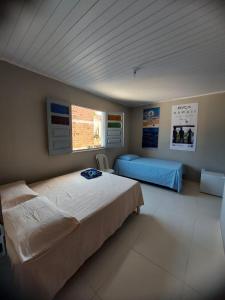 伊塔卡雷Suítes good trip itacare的一间卧室设有两张床和窗户。