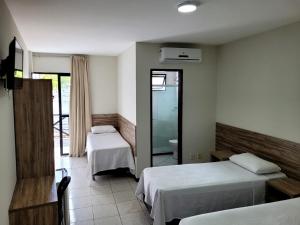 萨尔瓦多保萨达索拉里斯旅馆的酒店客房,设有两张床和镜子