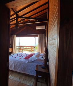 圣阿马鲁-达因佩拉特里斯Chalé da Montanha com Ofurô的一间卧室配有一张天蓬床和窗户