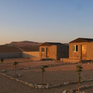 达纳Dana Sunset Eco Camp的一群有树木的沙漠中的建筑物