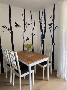 LindenVogelnest的餐桌和椅子,墙上挂着鸟和树木