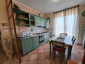 巴尼圣菲利波Apartament Thermae的厨房配有绿色橱柜和桌椅
