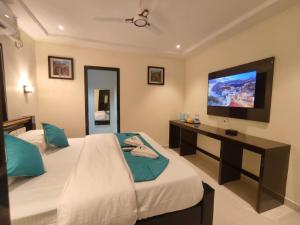 维沙卡帕特南Jazzy Beach Guest House的一间卧室配有两张床和一台平面电视