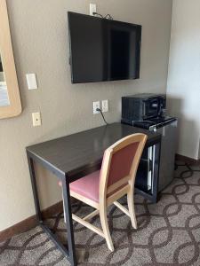 孟菲斯速7汽车旅馆的一张桌子,位于酒店的房间,配有椅子和电视