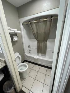 孟菲斯速7汽车旅馆的浴室配有卫生间和带淋浴的浴缸。