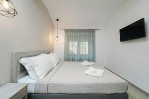 帕纳基雅Villa Oresti的卧室配有白色的床,墙上配有电视