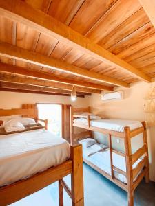 卡拉伊瓦Caramuru Hostel Caraíva的带木天花板的客房设有两张双层床。