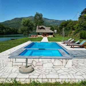 RezineVilla California的一座带石头庭院和房屋的游泳池