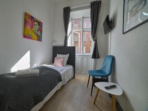 哥本哈根阿迈厄岛酒店的卧室配有床、椅子和窗户。