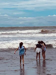 TamaniqueWabi Sabi , beach home的三人站在海滩的水面上