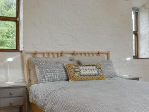 WookeyThe Chaff House的一间卧室配有一张带两张台灯的床铺。