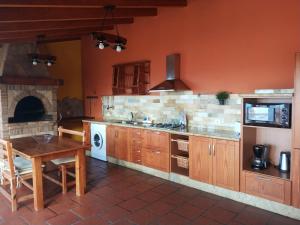 伊科德洛斯维诺斯Las Villas de Gardel的厨房配有桌子和炉灶。 顶部烤箱
