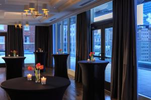 匹兹堡摩纳哥匹兹堡金普顿酒店的客房设有大窗户和鲜花桌