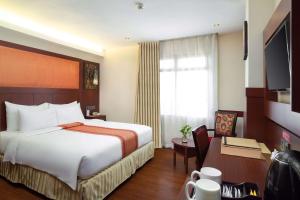 马卡萨马卡萨海滩贝斯特韦斯特高级酒店的酒店客房设有一张大床和一张书桌。