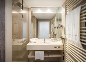 维也纳elaya hotel vienna city center的白色的浴室设有水槽和淋浴。