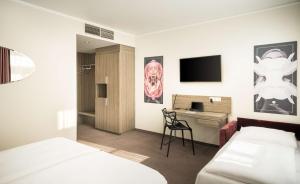 维也纳elaya hotel vienna city west的配有一张床和一张书桌的酒店客房