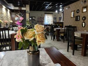 克鲁舍瓦茨Garni Hotel City的餐厅的桌子上一束黄色玫瑰花