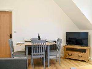 MarnhullThe New Inn Barn-uk31813的一间带桌椅和电视的用餐室