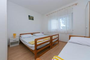 格拉达茨Apartments with a parking space Gradac, Makarska - 5198的一间卧室设有两张床和窗户。