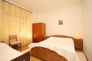 乌格连Apartments by the sea Ugljan - 348的一间卧室设有两张床、一个橱柜和一个窗口。