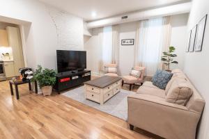 辛辛那提Spacious 2 bed 2 bath Downtown OTR condo minutes walk to the Reds Bengals stadium & more!的带沙发和平面电视的客厅