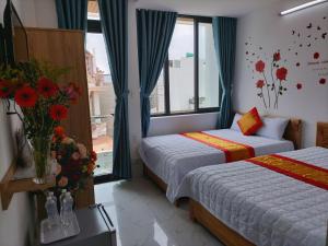 头顿Thảo Nguyên Hotel的酒店客房设有两张床和窗户。