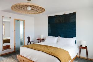 蒙托克盾斯信天翁汽车旅馆的一间卧室配有一张白色大床和绿色床头板