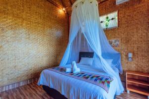 珀尼达岛艾杜森林小屋旅馆的一间卧室配有一张带蚊帐的床