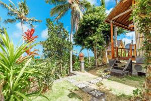 珀尼达岛艾杜森林小屋旅馆的热带花园,带门廊的房子