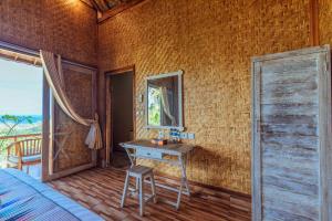 珀尼达岛艾杜森林小屋旅馆的一间卧室配有书桌、床和窗户。