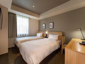 东京东京秋叶原菲诺贝斯特韦斯特酒店的酒店客房配有两张床和一张书桌