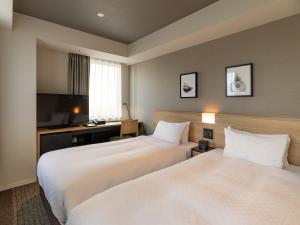 东京东京秋叶原菲诺贝斯特韦斯特酒店的酒店客房设有两张床和电视。