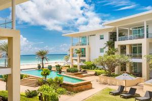 卡伦海滩Happy Apartment on Karon Beach的享有带游泳池和海滩的度假村外部景色