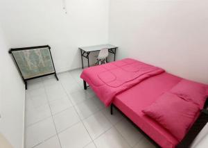 马六甲D'Luna Homestay Melaka Fully Aircond的卧室配有粉红色的床和桌子