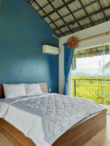 会安Nha Bong Villa的一间卧室配有一张蓝色墙壁和窗户的床