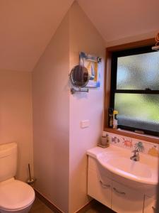 怀蒂昂格城堡树梢木屋的一间带卫生间、水槽和窗户的浴室