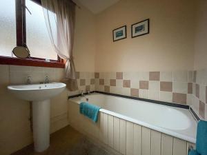 金洛赫伯维Bervie Road Cottage的浴室配有盥洗盆、浴缸和盥洗盆
