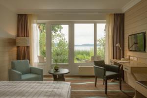 拉策堡德施霍夫酒店的酒店客房设有一张床、两把椅子和一扇窗户。