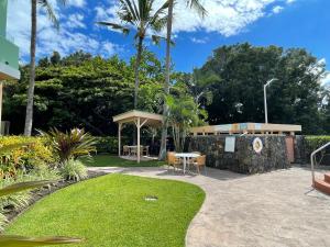 科纳Beach Villas at Kahalu'u的天井设有桌子、长凳和草地。