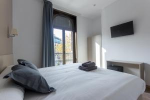 巴塞罗那Hostalin Barcelona Passeig de Gracia的卧室配有一张大白色床和窗户