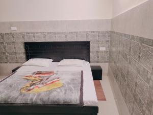 格德拉Vidya Guest House的一间卧室设有一张带砖墙的大床