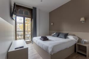 巴塞罗那Hostalin Barcelona Passeig de Gracia的一间卧室设有一张大床和一个窗户。